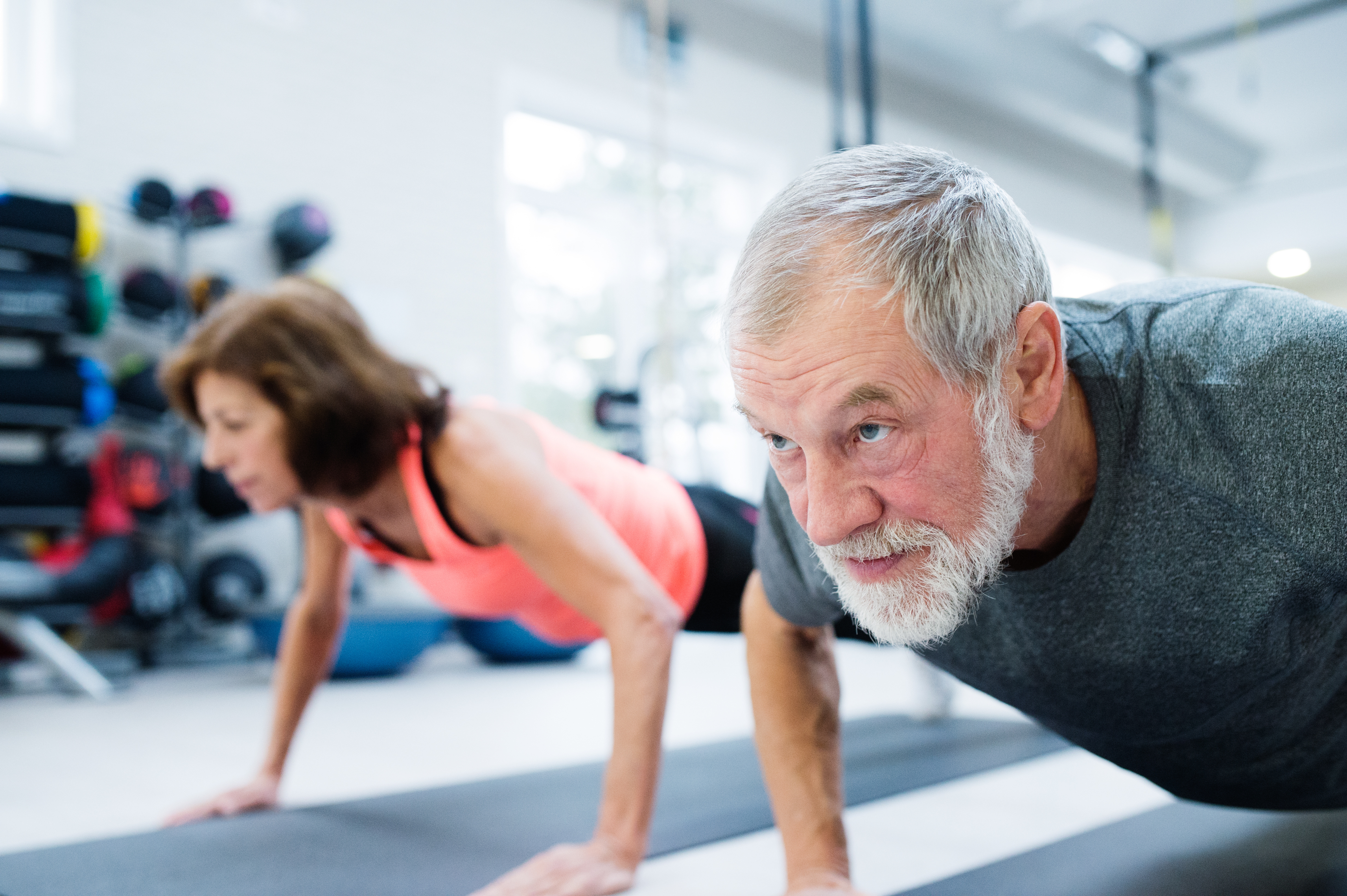 Older senior couple exercising in gym